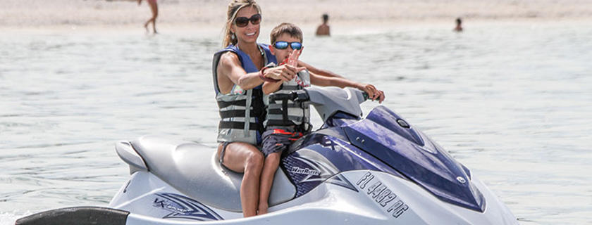 A mother and son on a jet ski smiling