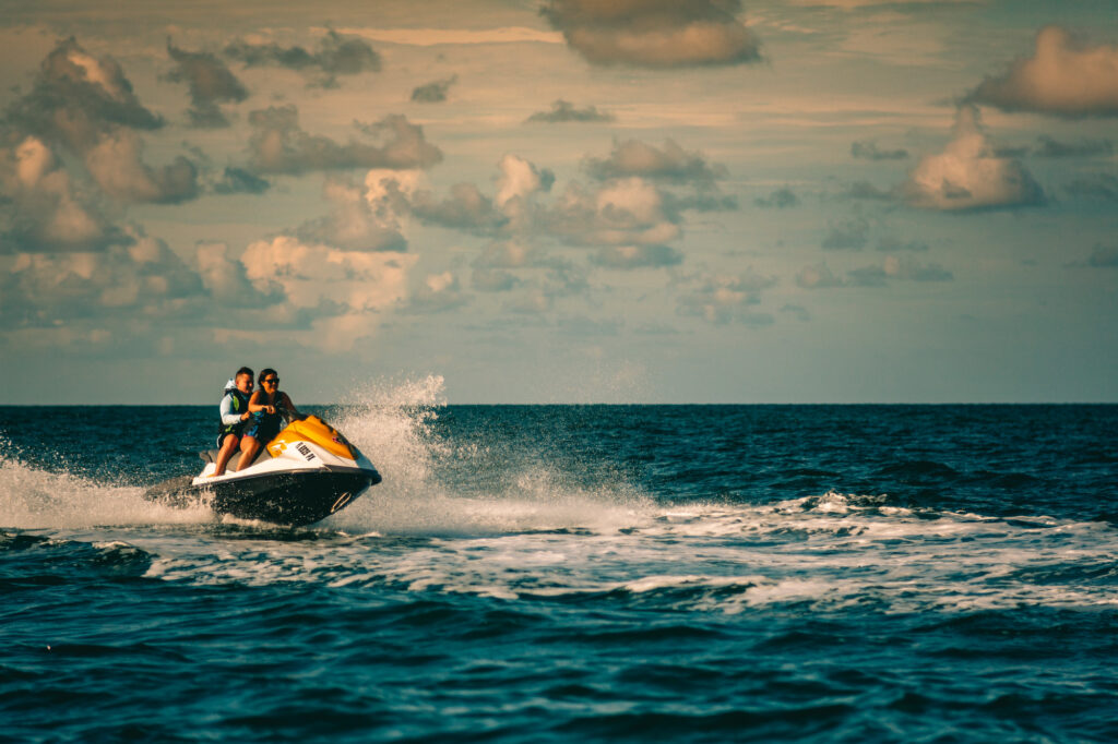 A man and woman rising off of the water while jetsking